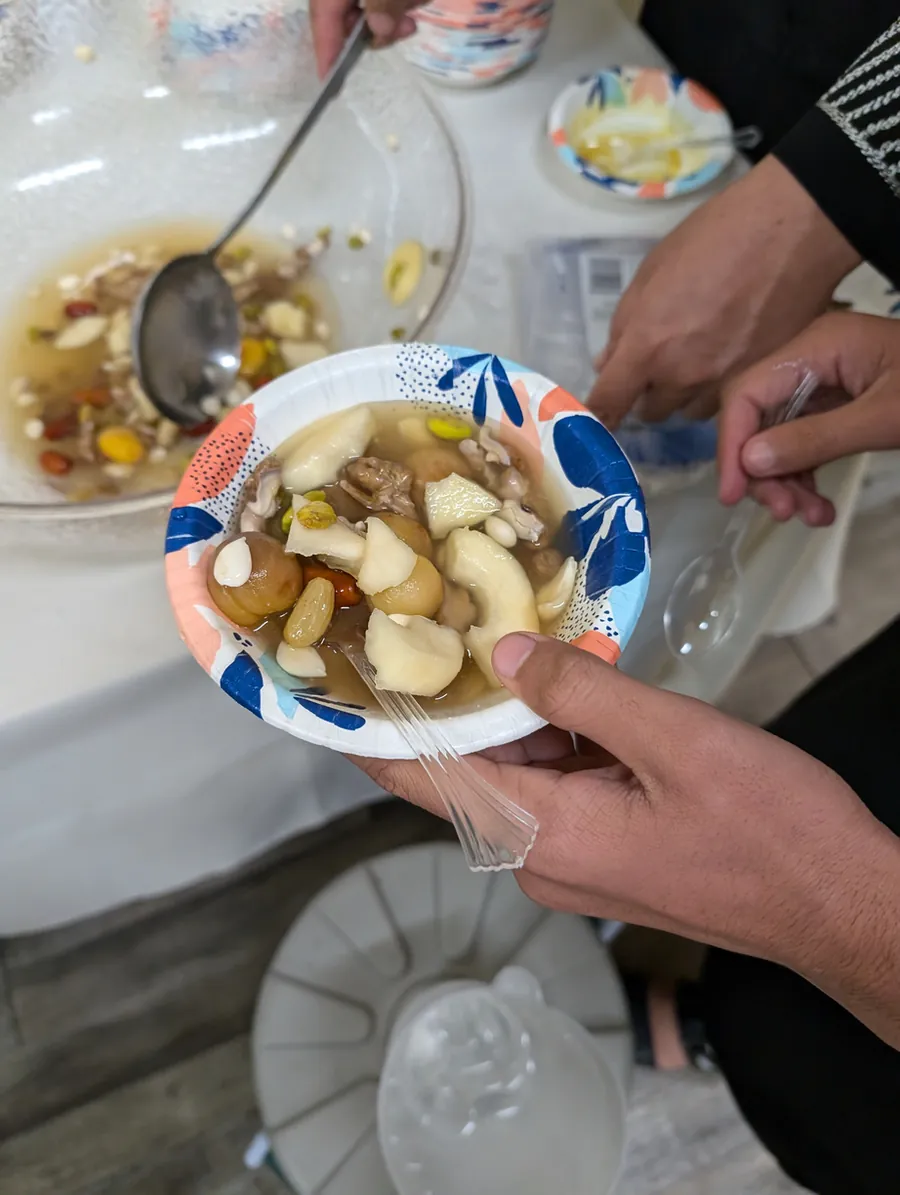 Two hands holding a bowl of soup at a FIRM community meal.
