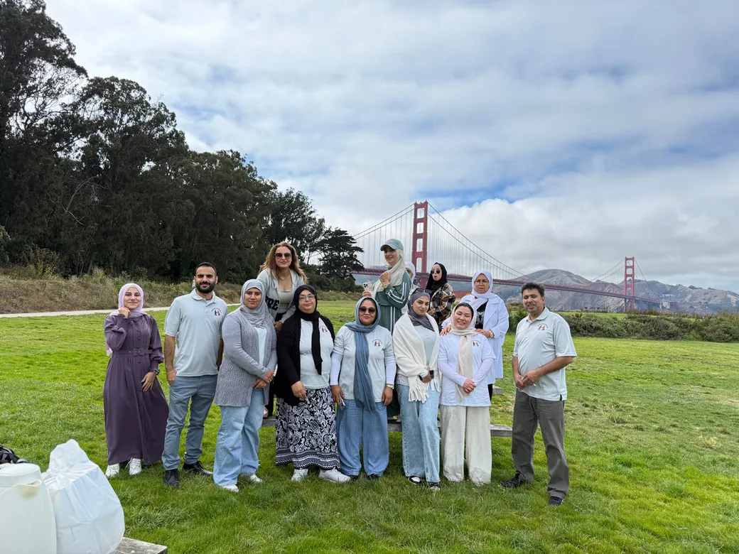 A FIRM group standing on the grass at the Golden Gate Bridge on a day trip.