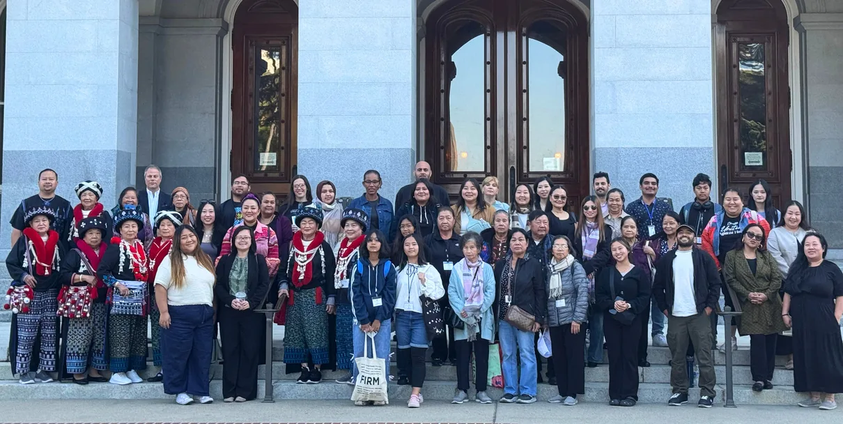 About forty people from FIRM's communities, many in Hmong and Lao dress, standing together on the granite steps of the California State Capitol.